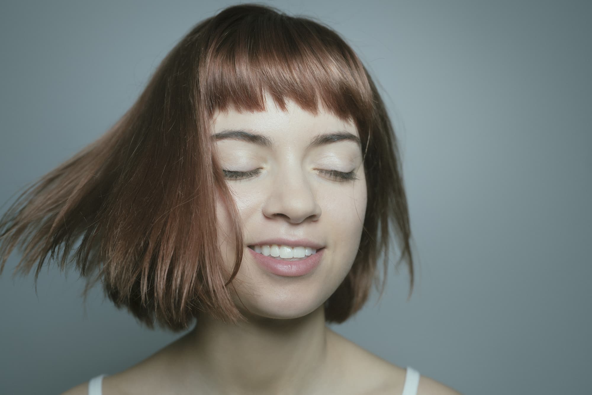 髪を動かしてるボブスタイルの女性